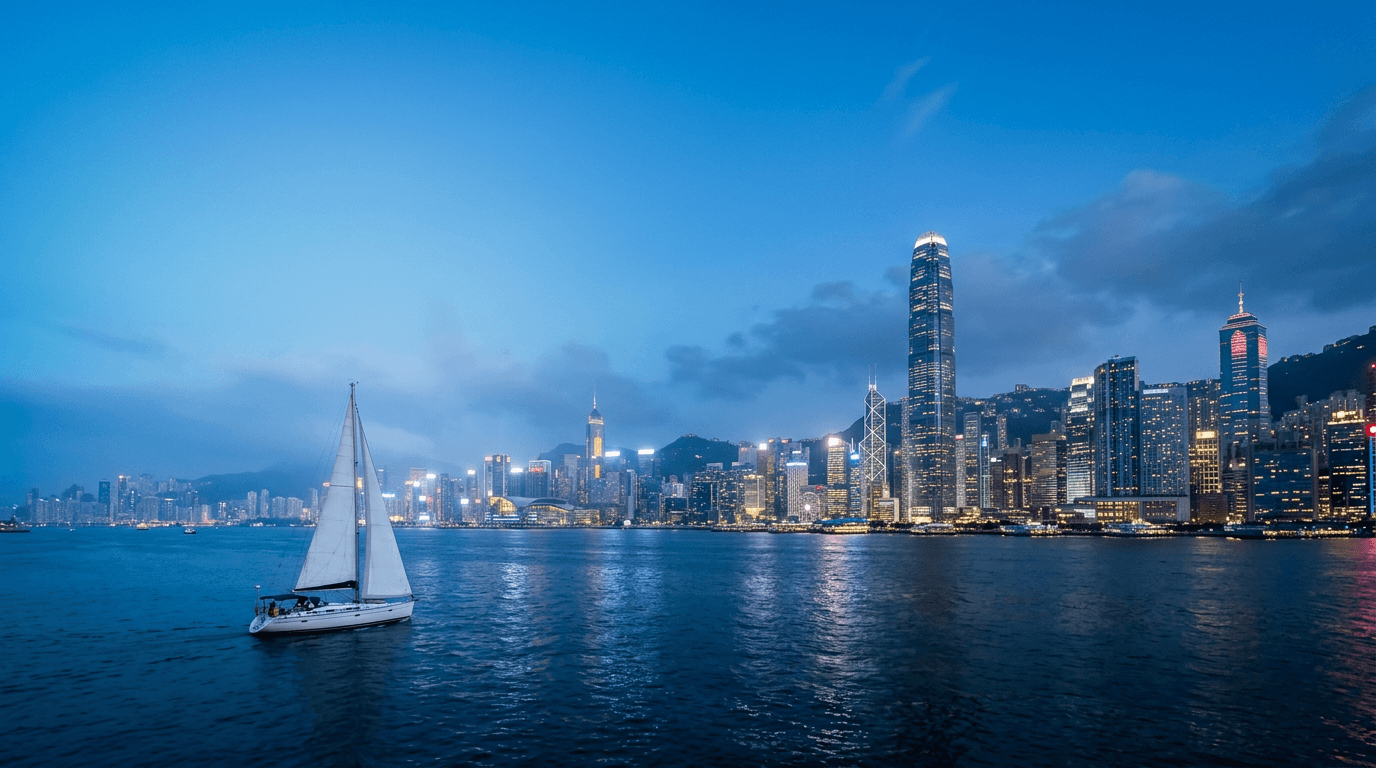 香港維多利亞港夜景,海面上有一艘揚帆的白色帆船